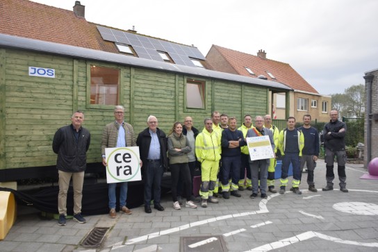 Groep mensen poseert voor een de rustmobiel van gemeentelijke basisschool De Pagaaier in Sint-Joris. (vergroot foto)